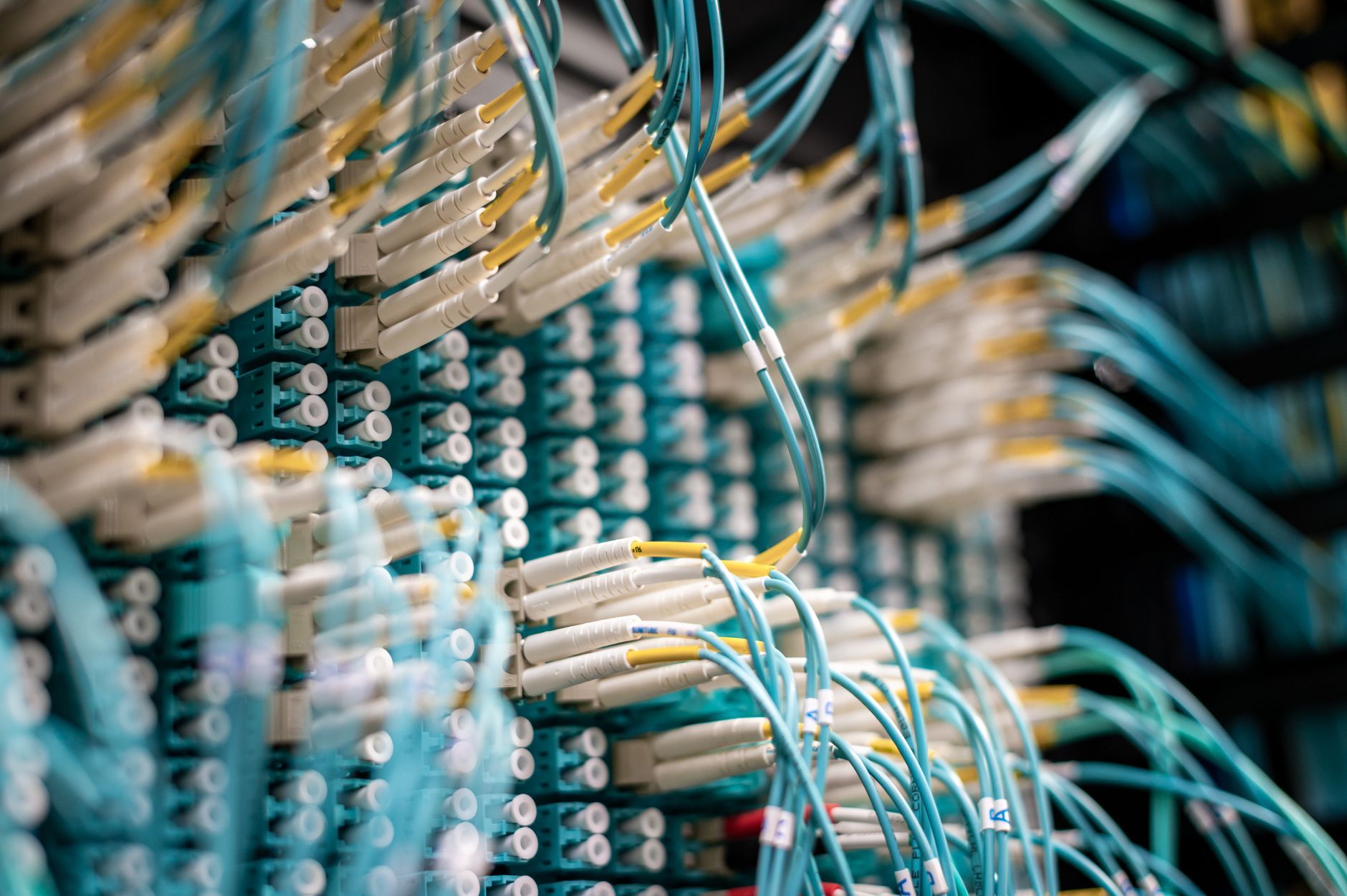 Equipos de red con conexiones de fibra óptica iluminadas.
